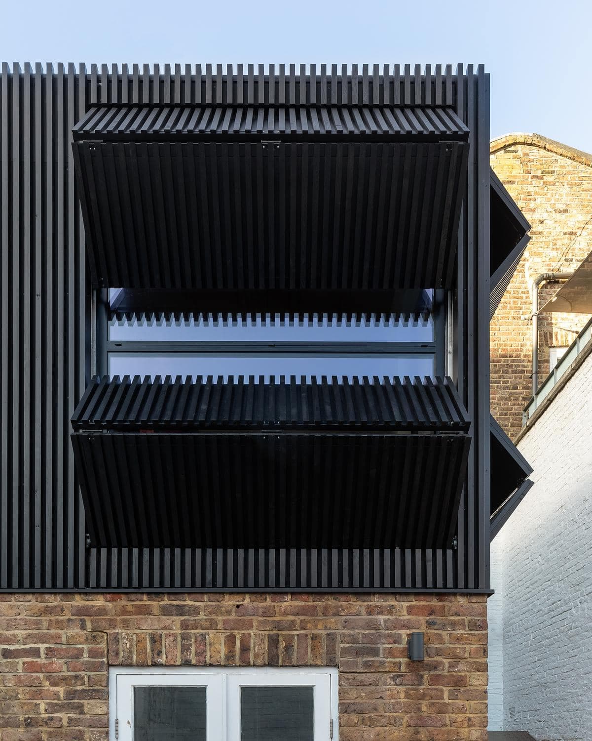 Angled view of the facade with its shutters open.