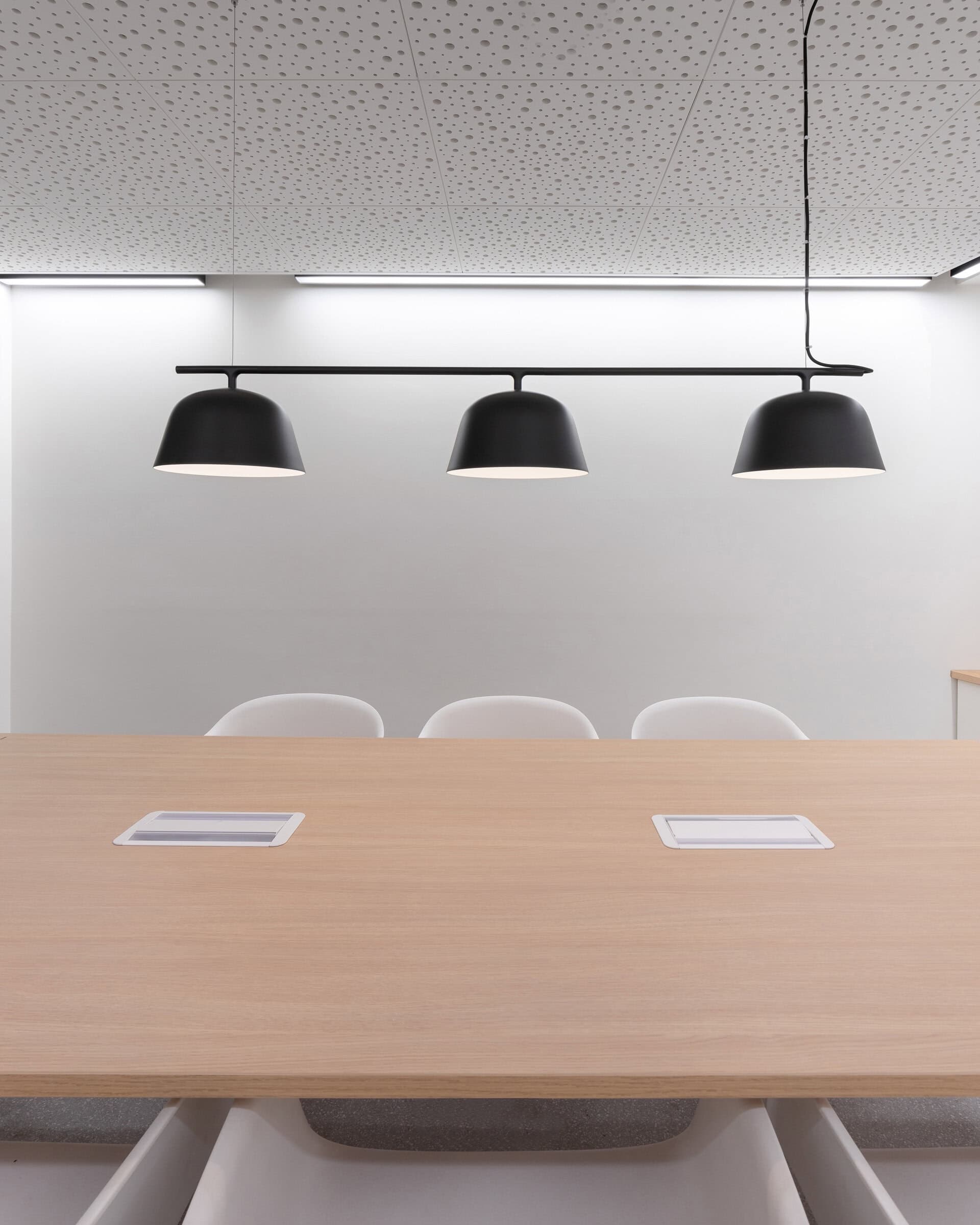 Meeting table beneath a pendant light.