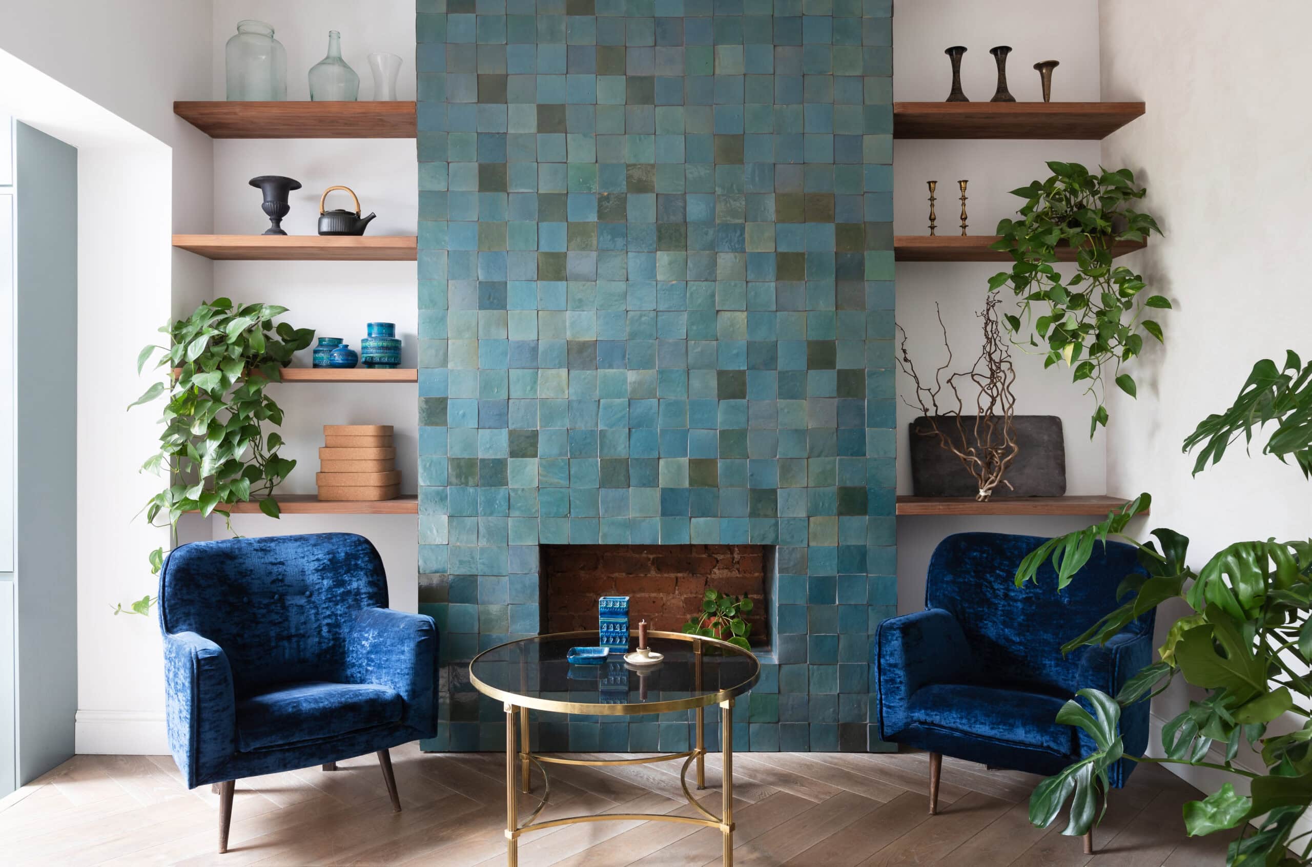 Blue chair beside a tiled fireplace.