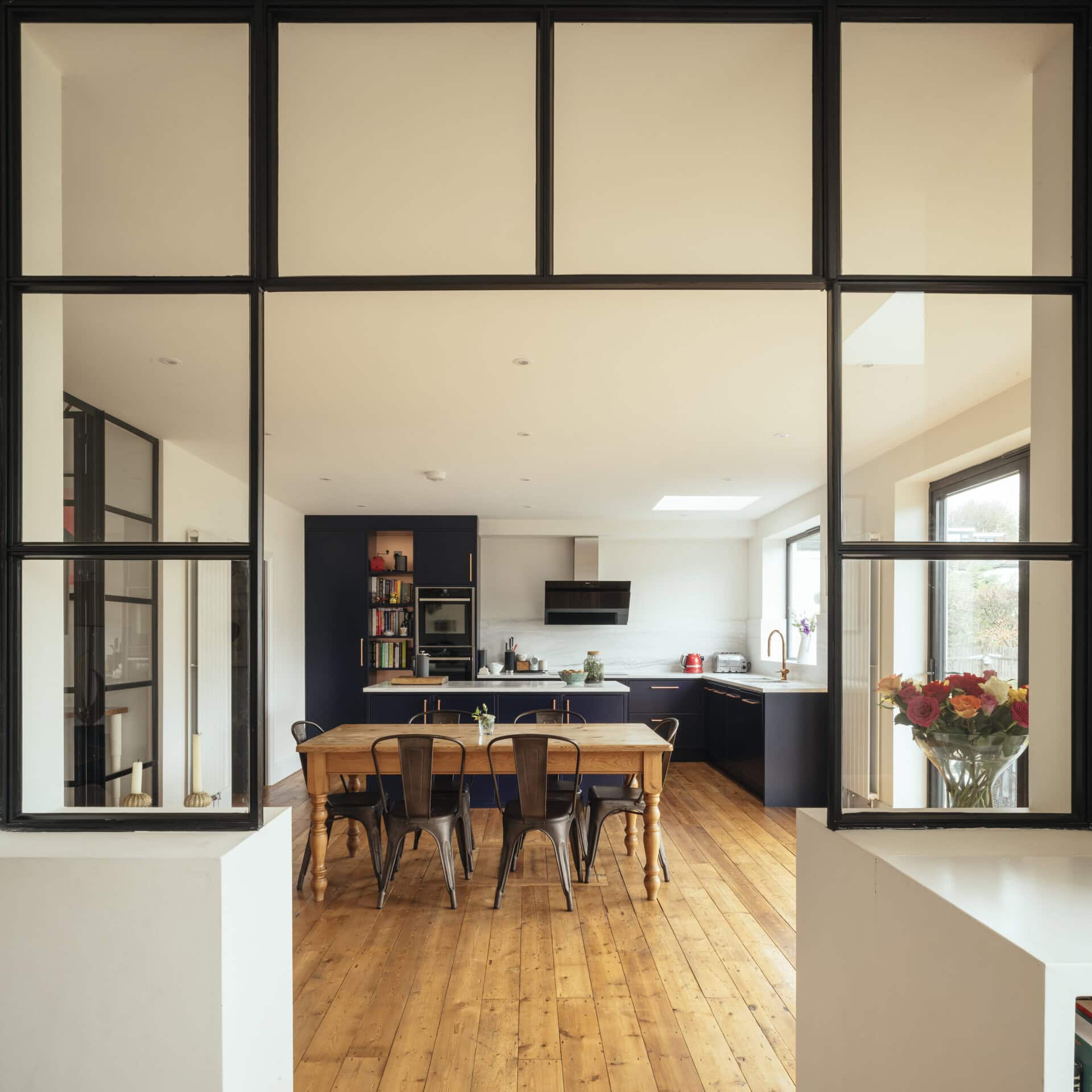View through a framed opening between dining and kitchen spaces.