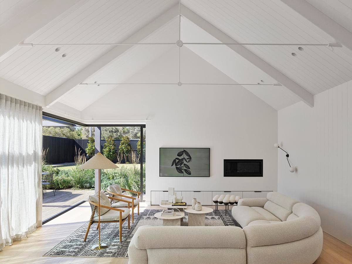 Stylish modern living room with vaulted ceiling, natural light, and comfortable furnishings.