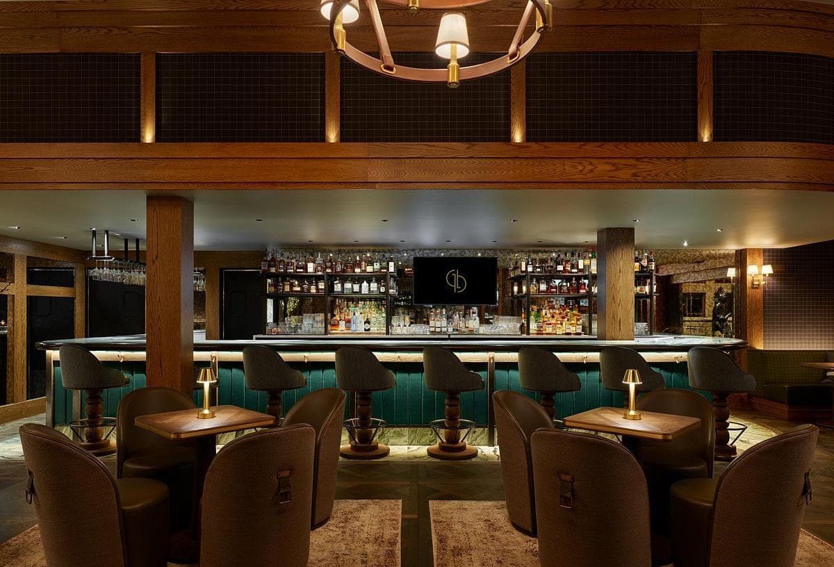 Elegant bar with teal accents, plush seating, and warm lighting for a cozy ambiance.