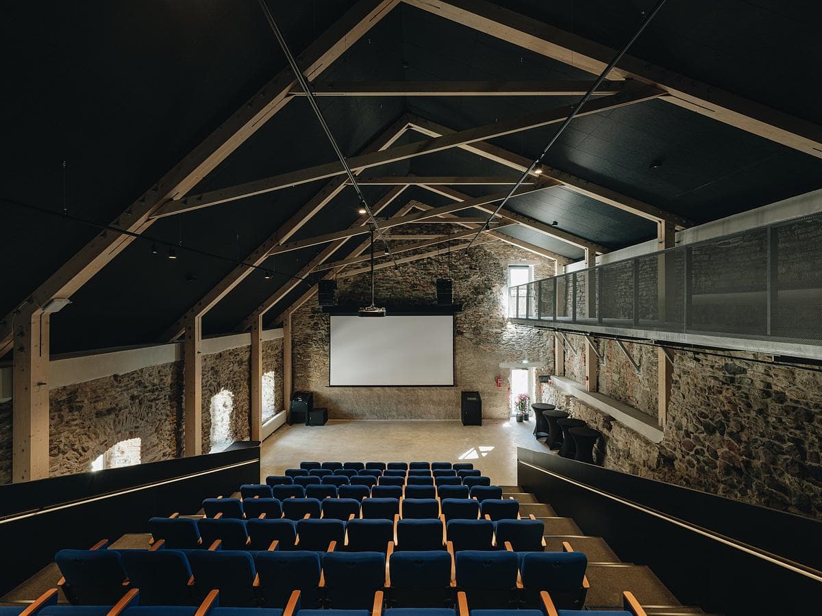Spacious modern auditorium blending contemporary design with historical architecture for community events.