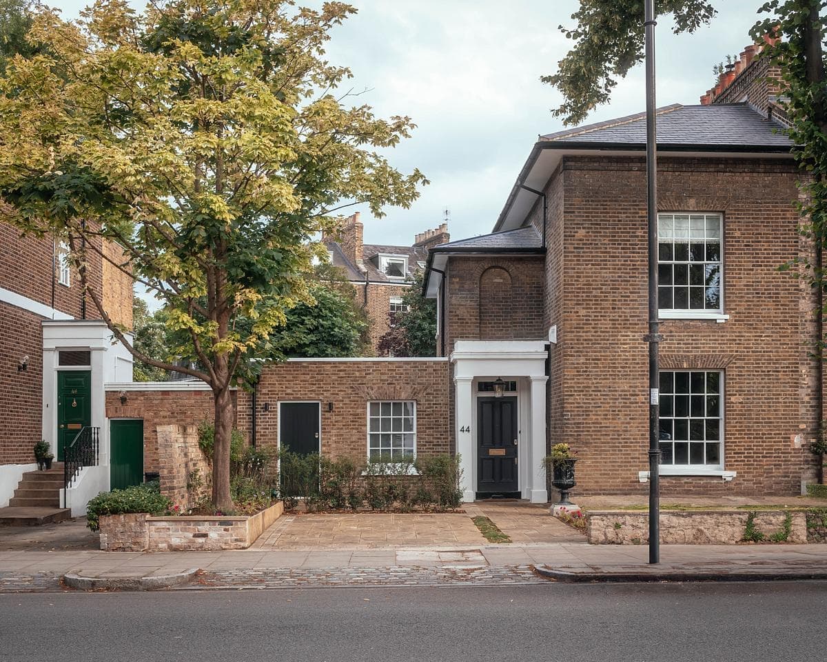 Charming homes blend modern and traditional architecture in a serene, leafy residential street.