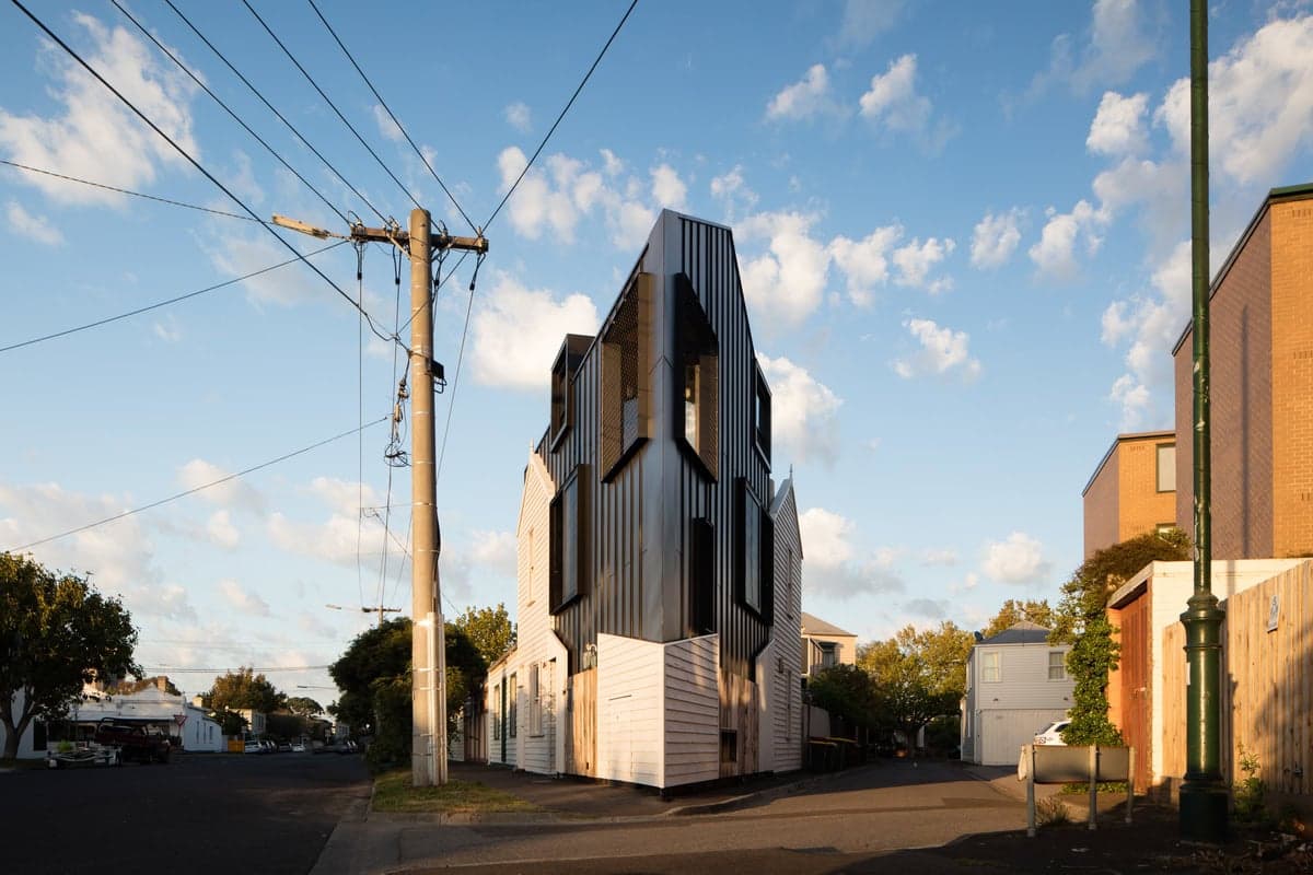 Innovative modern architecture contrasts traditional homes in a vibrant urban setting.