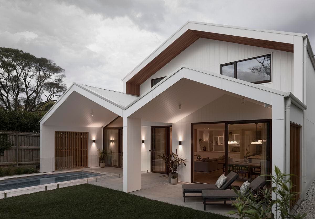 Contemporary minimalist home with pool, surrounded by serene greenery and inviting outdoor spaces.