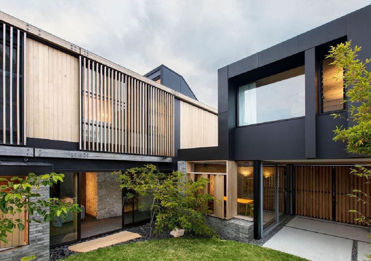 Modern home showcasing sleek design, natural materials, and harmonious landscaping for a tranquil living experience.