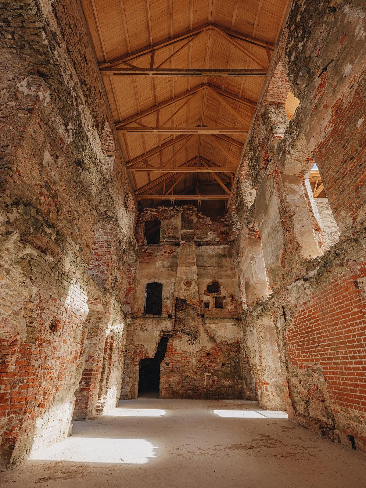 Historic masonry interior beneath a new timber roof.