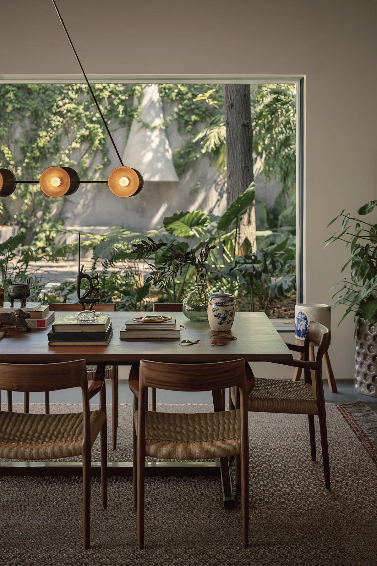 Inviting dining area with natural light, wooden decor, and lush greenery views.