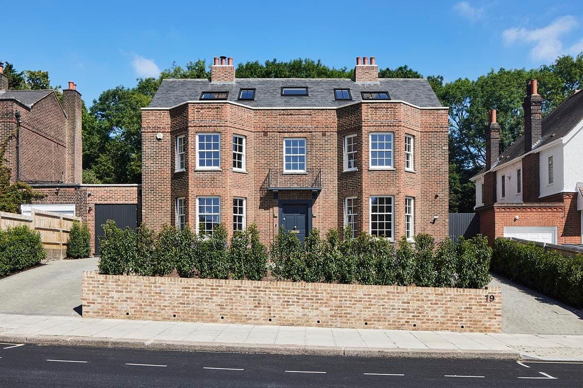 Charming brick home with elegant design, lush landscaping, and contemporary features in a serene setting.