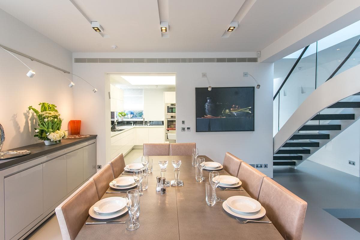 Elegant modern dining room featuring minimalist decor and vibrant artwork for sophisticated gatherings.