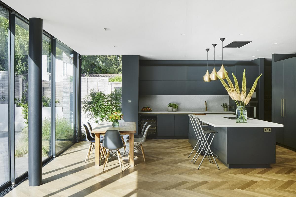Sleek modern kitchen and dining area with natural light and elegant decor.