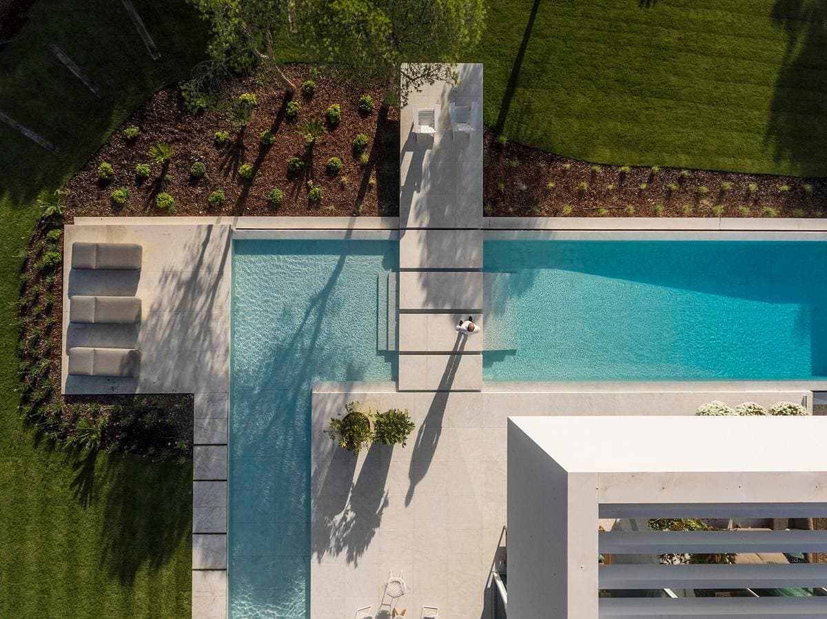 Stylish swimming pool oasis with modern loungers and lush greenery for tranquil outdoor living.