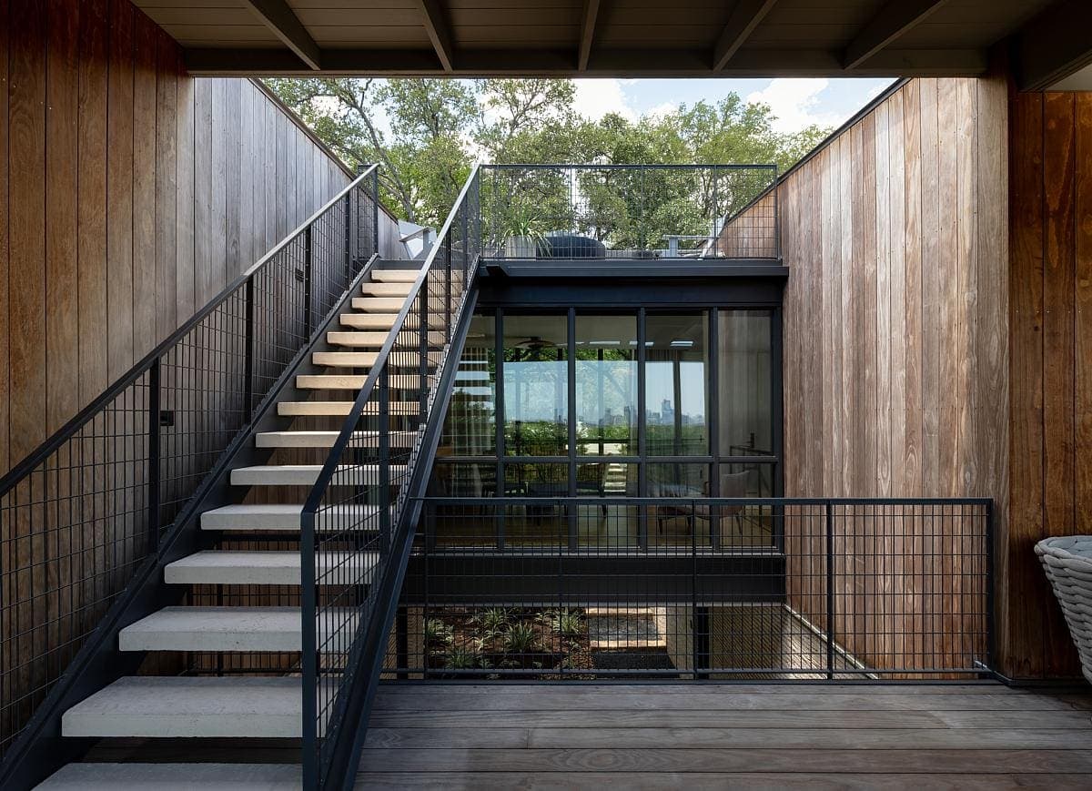 External timber staircase and landings between timber-clad walls.