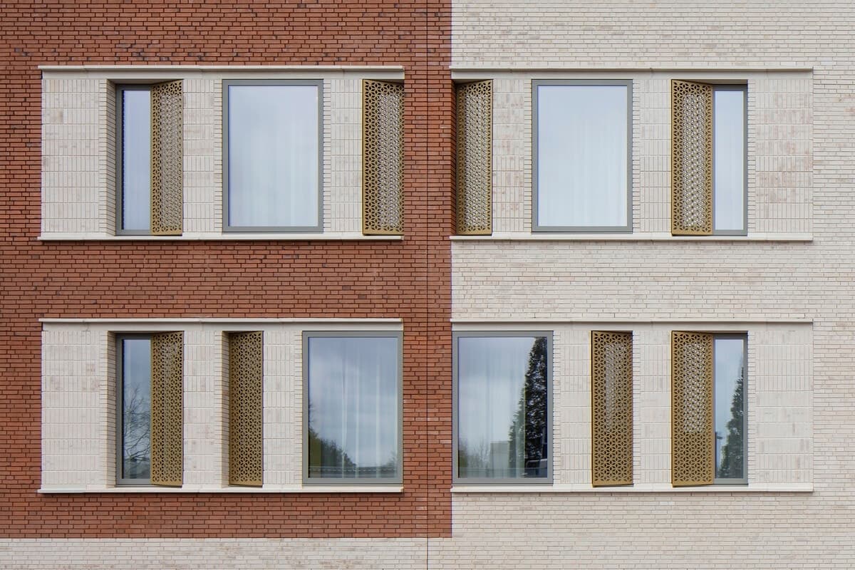 Dual-tone brick facade of symmetrical healthcare clinic with decorative windows.