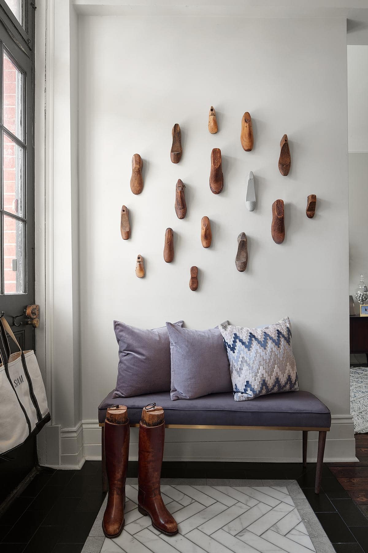 Inviting modern rustic entryway with artistic wooden wall, sleek bench, and natural light.