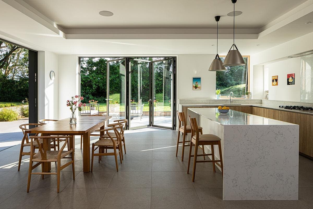 Bright modern kitchen and dining area with natural light and elegant furnishings.