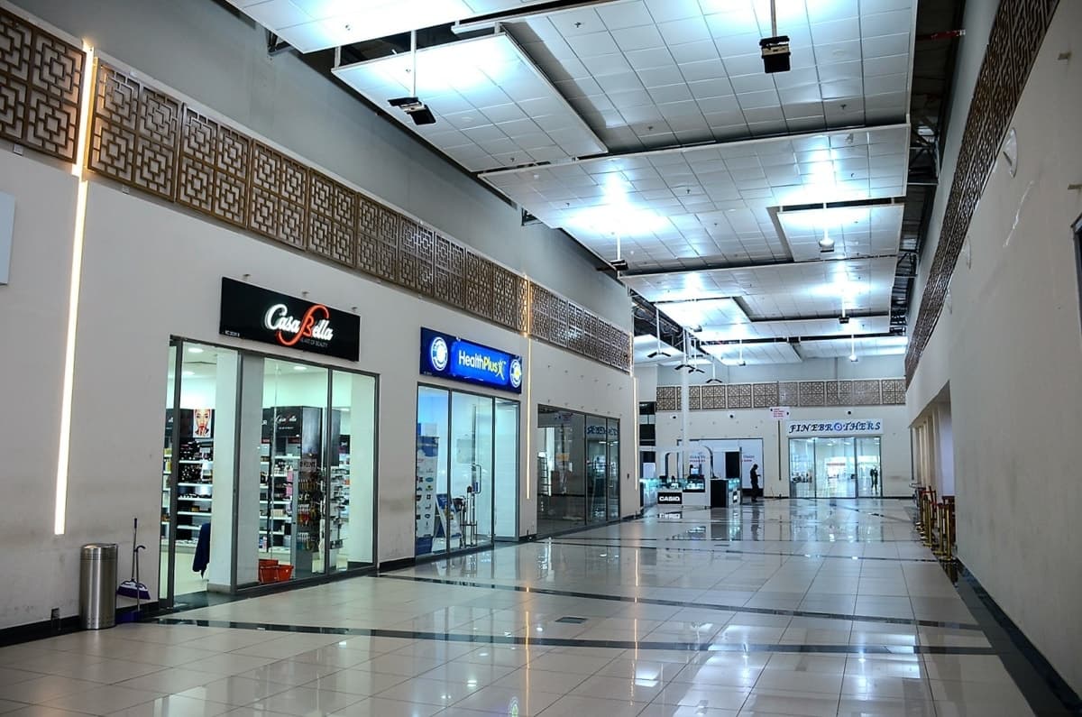 Modern interior view of Calabar Shopping Mall with glossy tiles and well-lit storefronts.