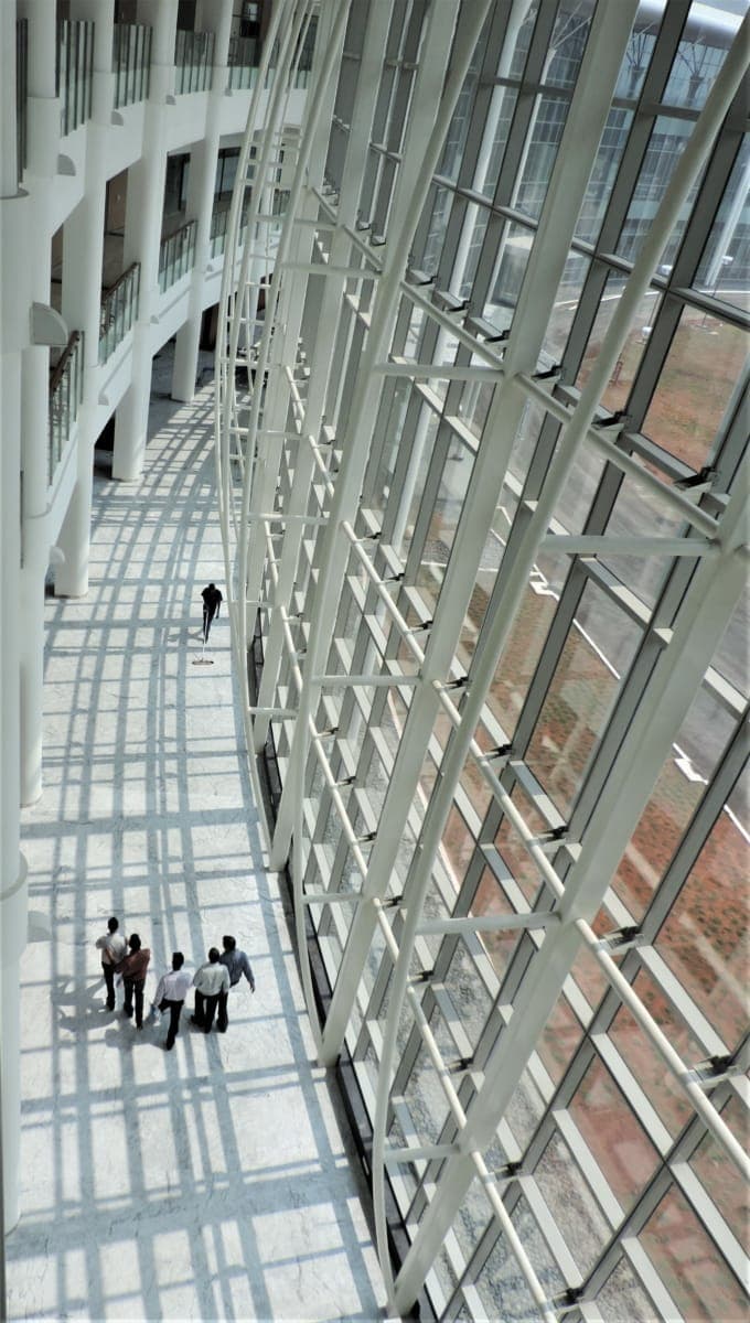 Sweeping glass corridor at Reliance Technology Group Research Facility.