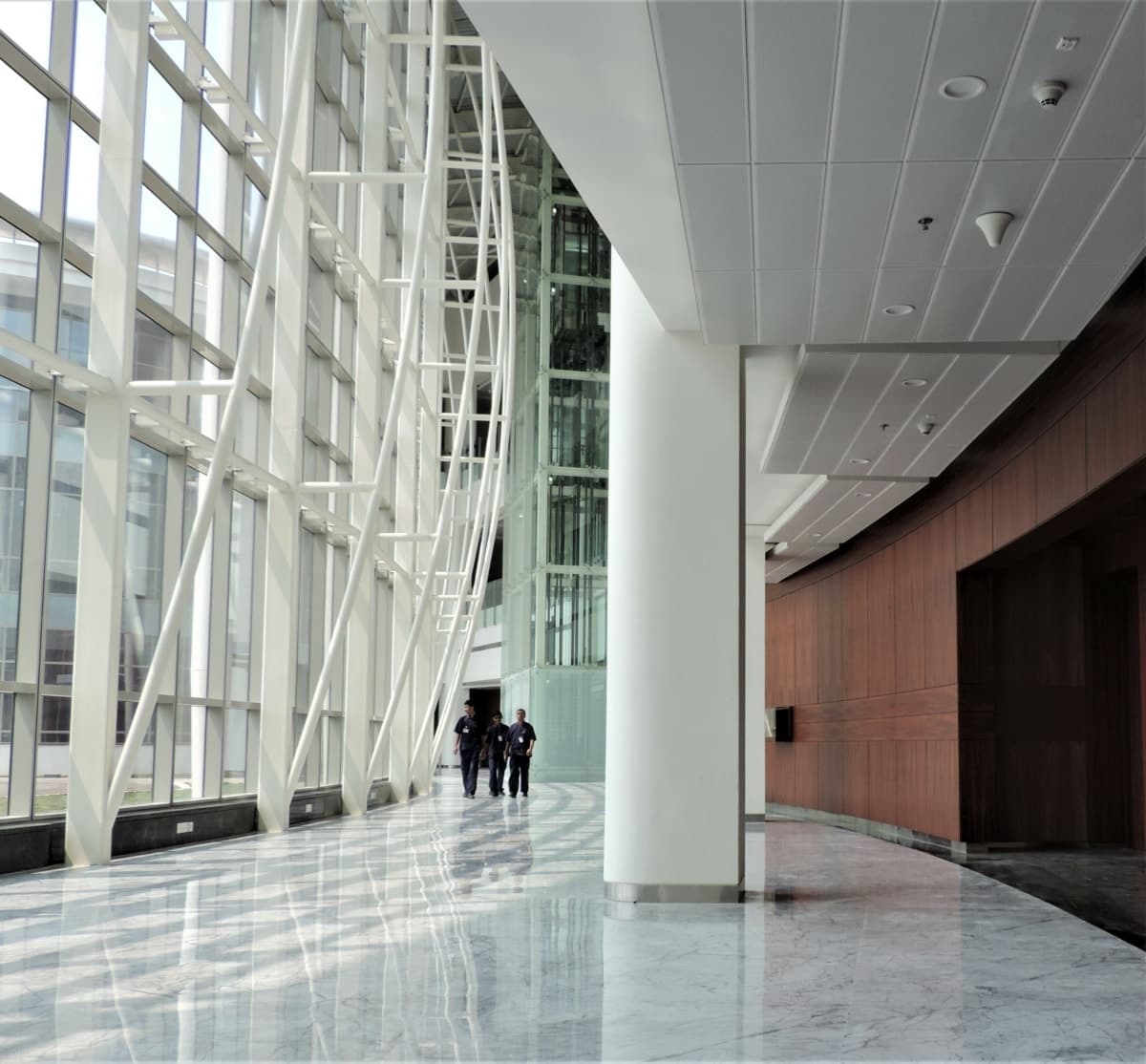 Modern glass-walled corridor at Reliance Technology Group Research Facility.
