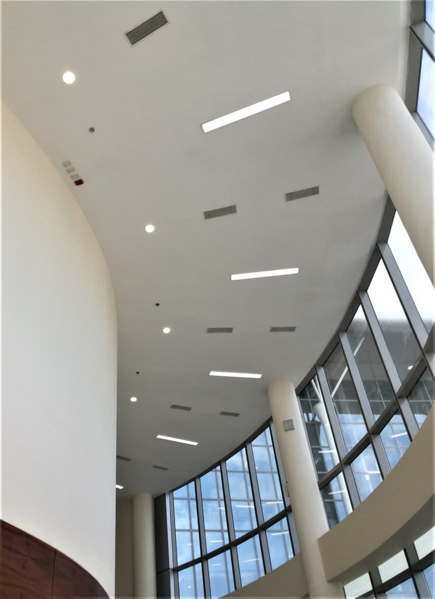 Modern research facility interior with curved wall and floor-to-ceiling windows.