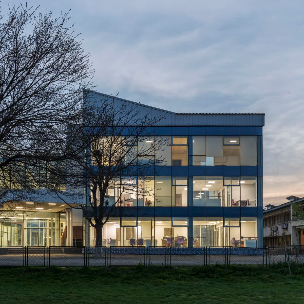 Kashmir University Administration Building at twilight, featuring modern glass and steel architecture.