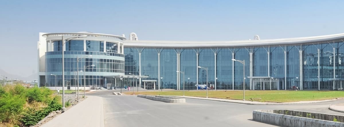 Modern glass and steel Reliance Technology Group Research Facility with cylindrical and curved sections.