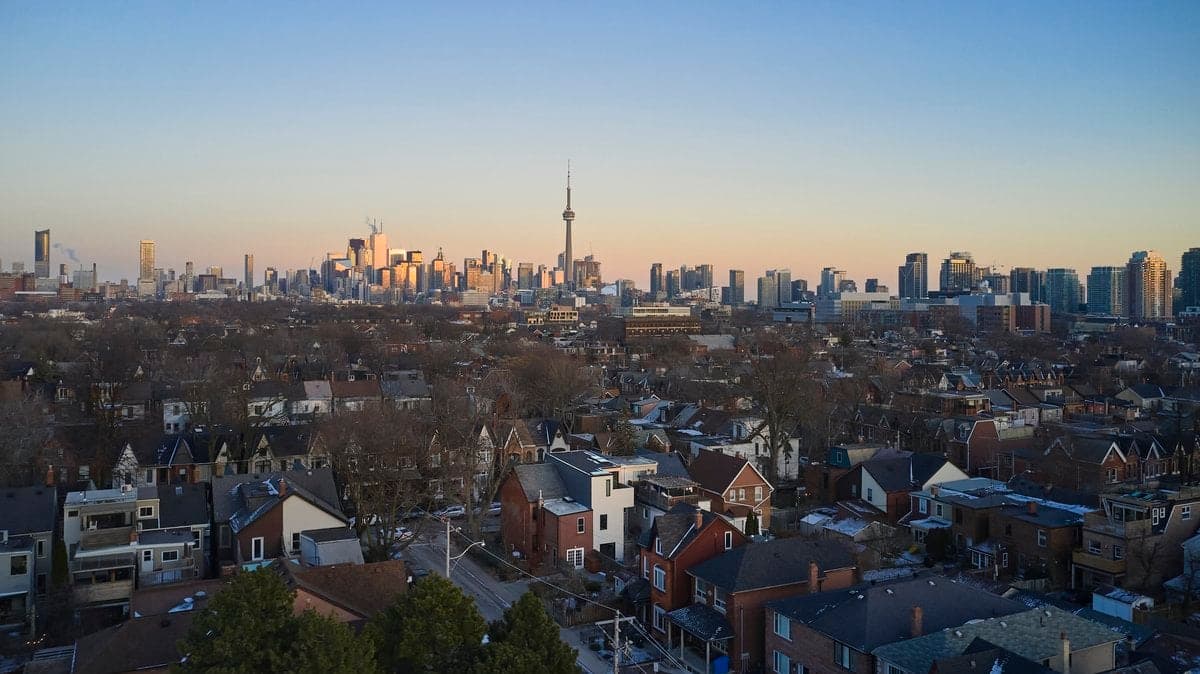Aerial view of a cityscape at sunset featuring residential and commercial areas.