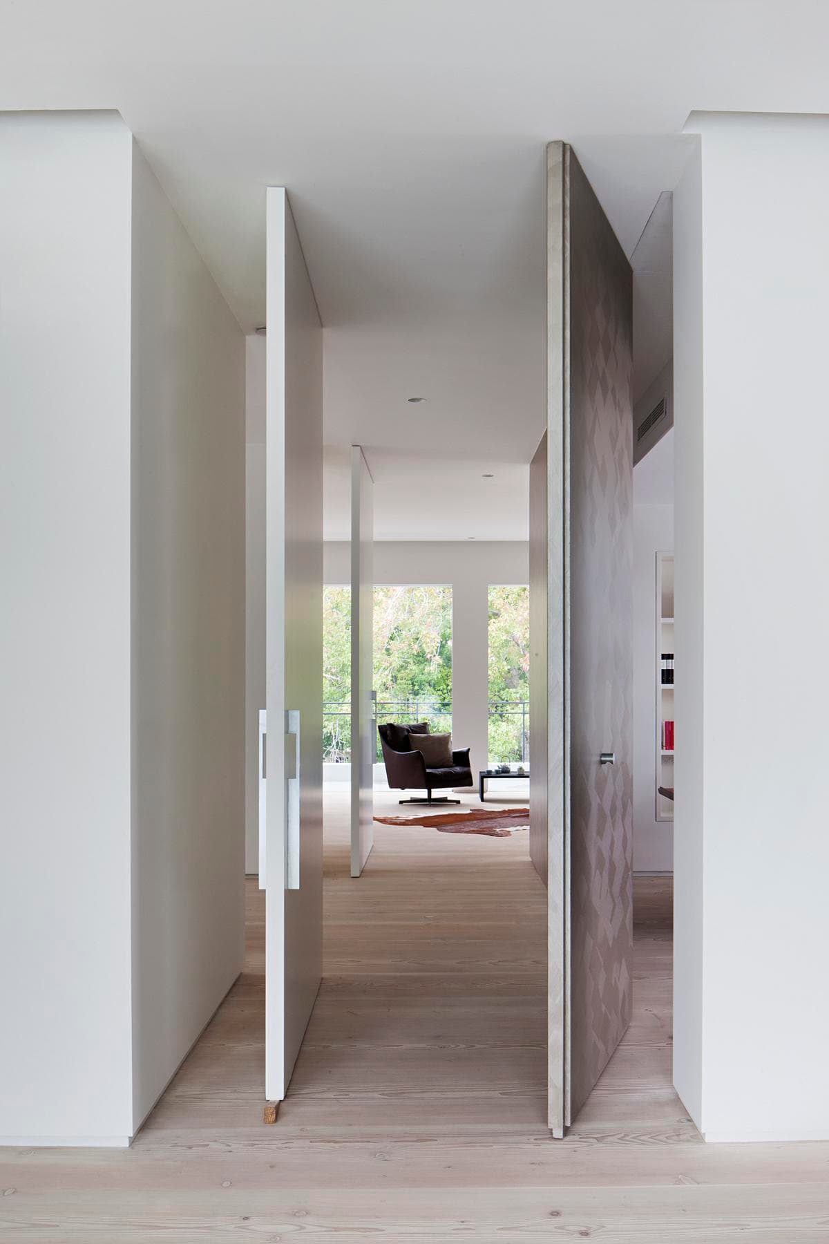 Minimalist interior with contrasting doors, natural light, and a serene connection to nature.