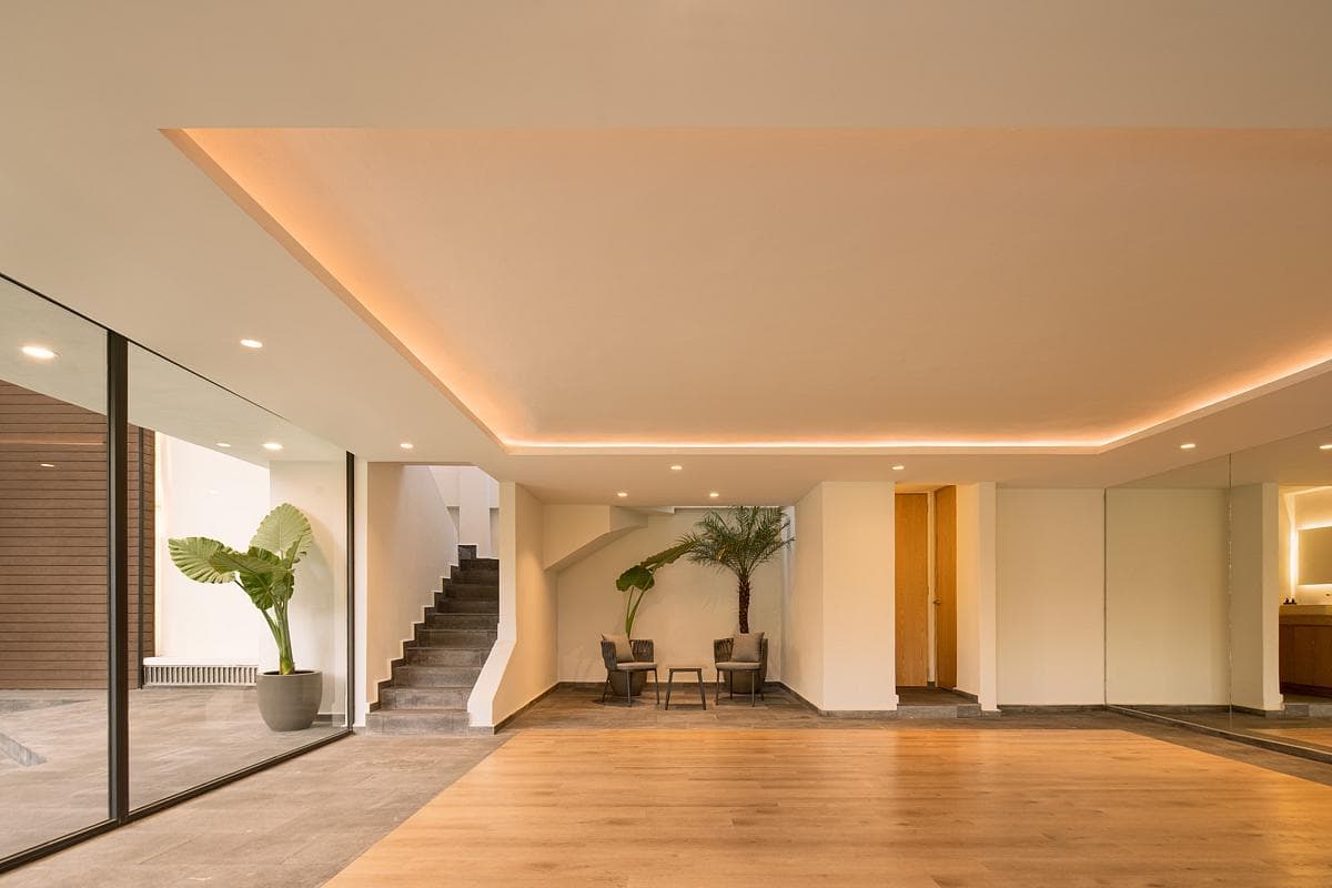 Spacious minimalist interior with light wooden floors and abundant natural light.