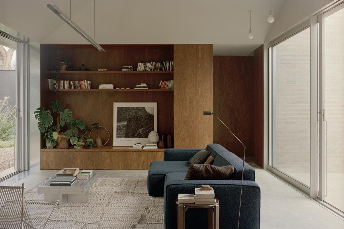 Elegant minimalist living room bathed in natural light with stylish decor and lush plants.