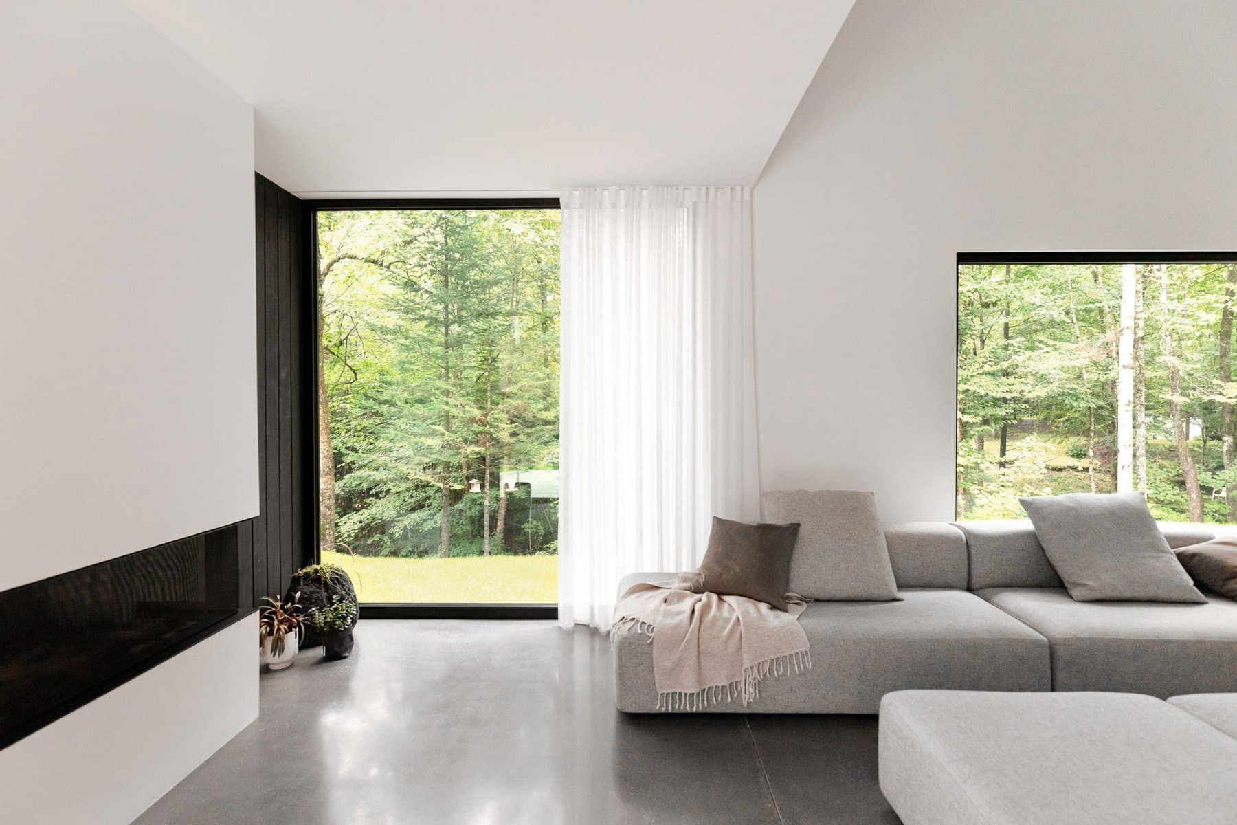 Contemporary minimalist living room showcasing natural light and a seamless indoor-outdoor connection.