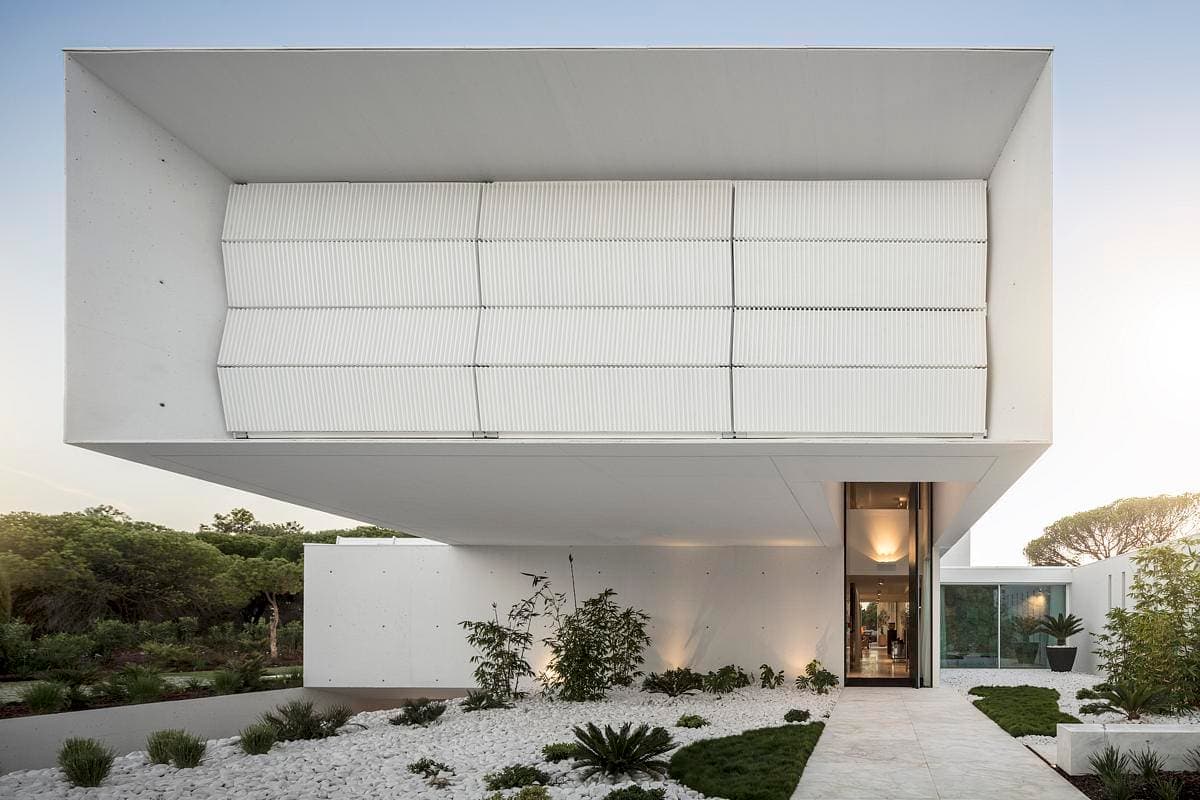 Stunning minimalist architecture featuring a floating upper level and elegant landscape design.