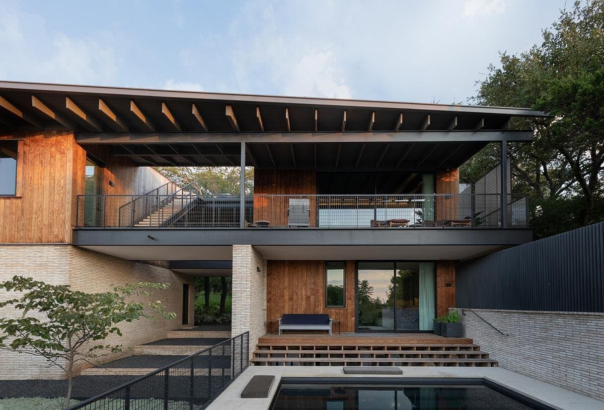 Contemporary home design featuring natural materials, spacious outdoor areas, and a serene pool.