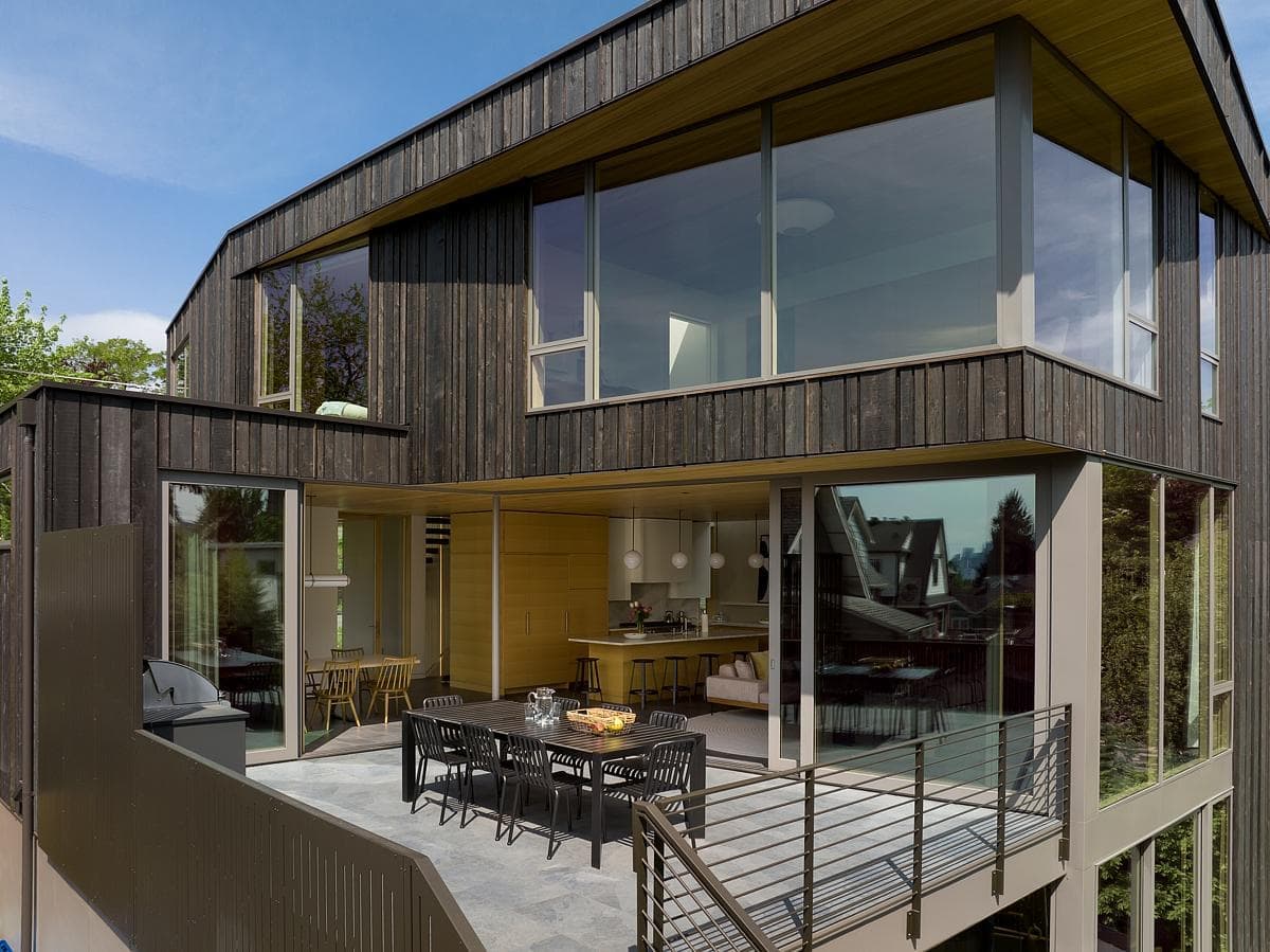 Modern architectural masterpiece with a terrace for alfresco dining amidst lush greenery.