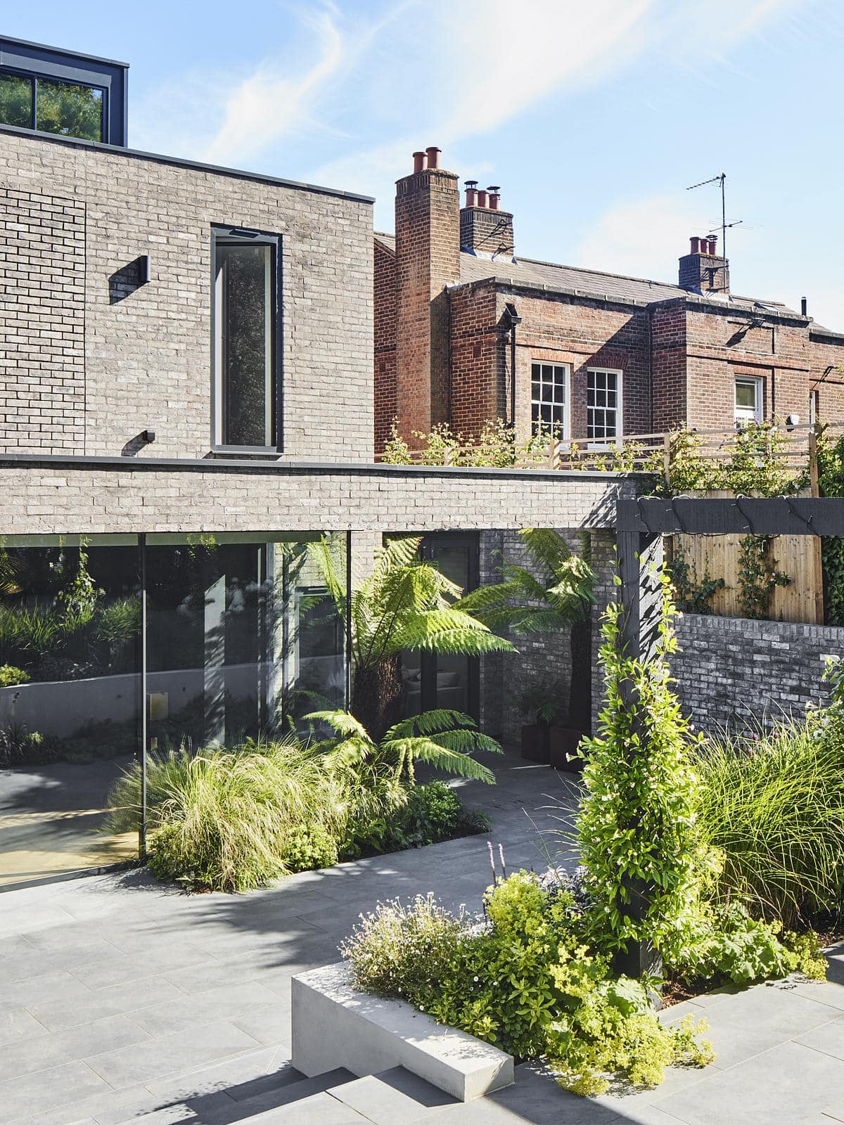 Contemporary architecture harmonises with historic buildings amid a lush urban garden landscape.