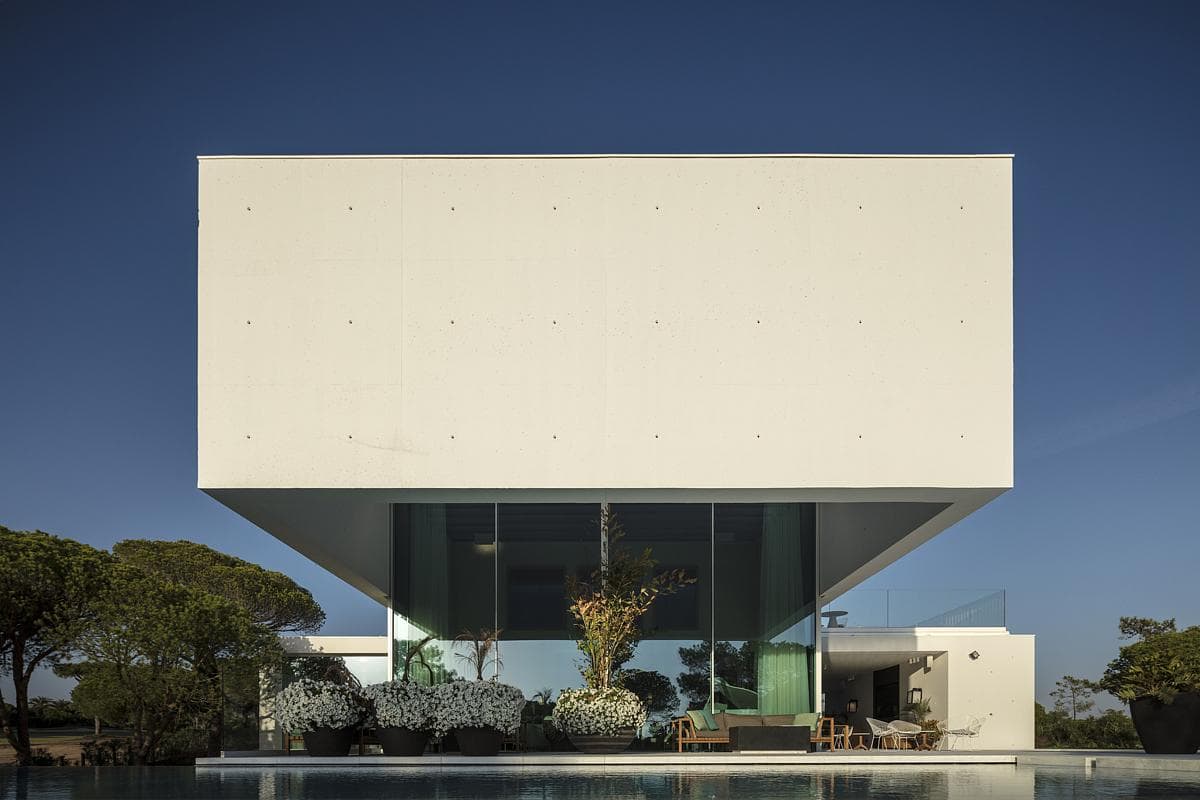 Contemporary minimalist cube architecture with seamless indoor-outdoor living and stunning natural surroundings.