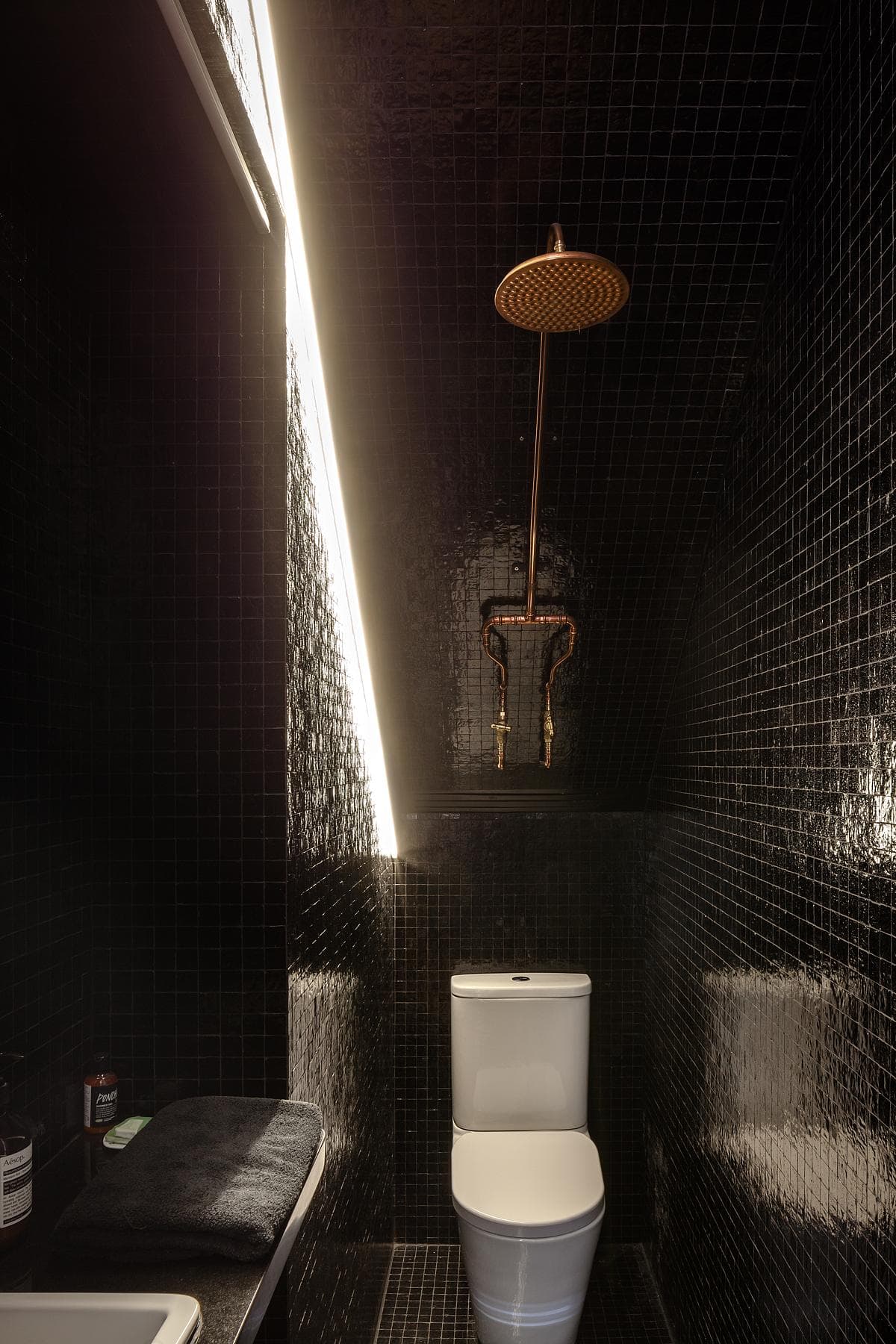 Stylish black and white bathroom featuring gold accents and minimalist design elements.