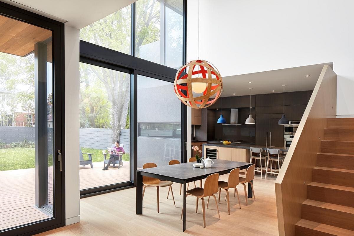 Open-concept modern dining and kitchen area with minimalist design and outdoor view.
