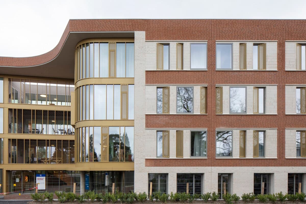 Modern multi-story healthcare clinic with glass atrium and landscaped exterior.