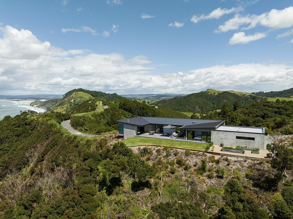 Modern hillside home featuring ocean views, sleek design, and lush landscaped surroundings.