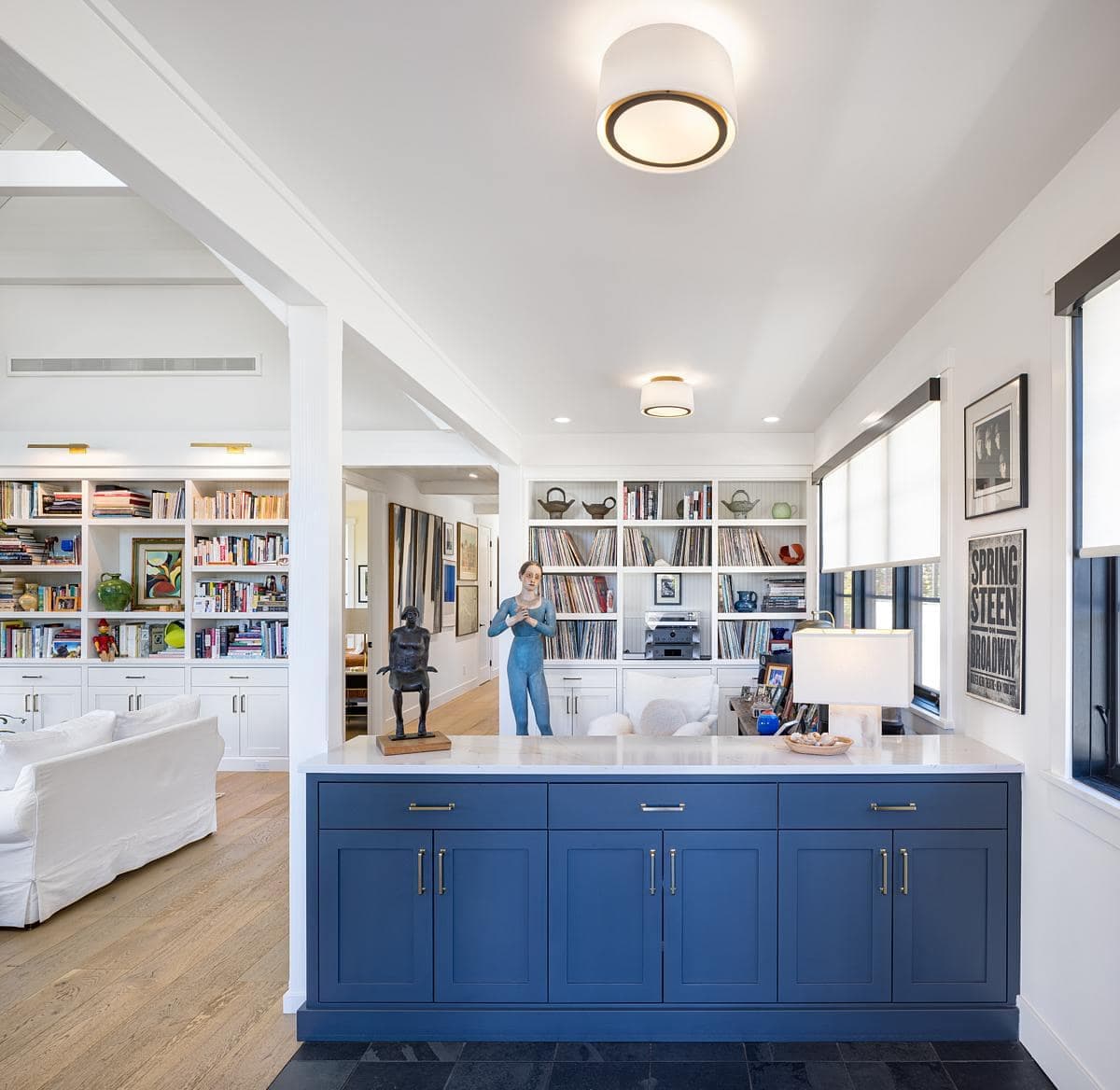Bright modern home office featuring stylish cabinetry and a cozy reading nook.