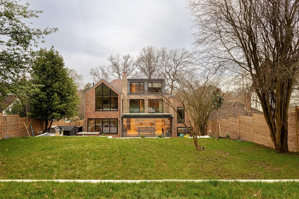 Rear view of a multi-level brick house from the garden.