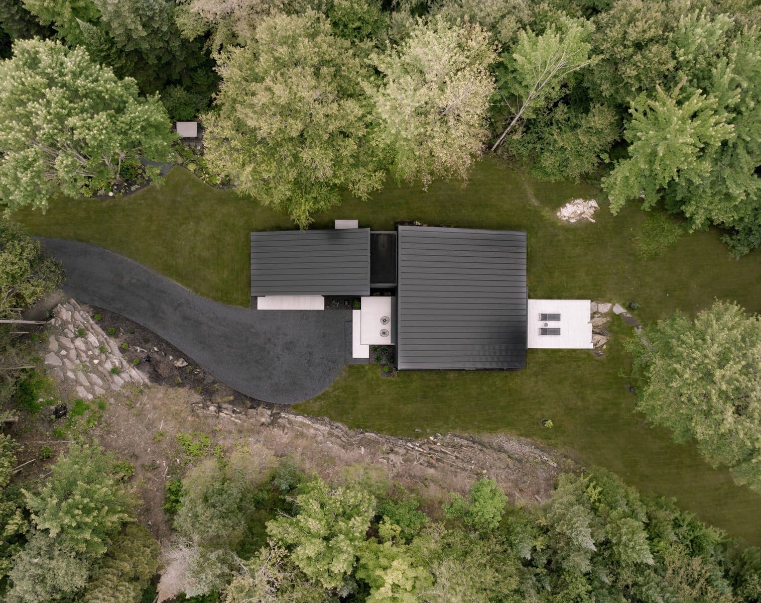 Contemporary house elegantly integrated into a lush green landscape for serene living.
