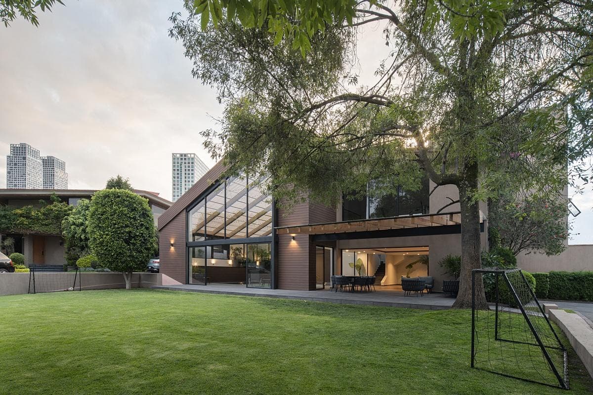 Contemporary urban house blending glass and brick amidst a tranquil landscaped garden.