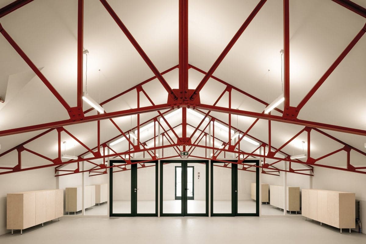 Spacious modern industrial interior with striking steel beams and abundant natural light.