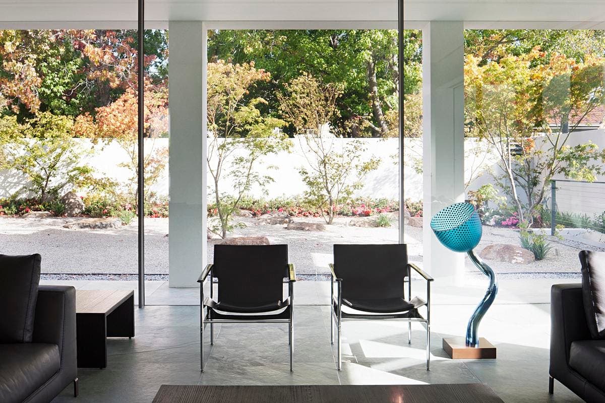 Stylish modern living room with large windows showcasing a beautiful garden view.