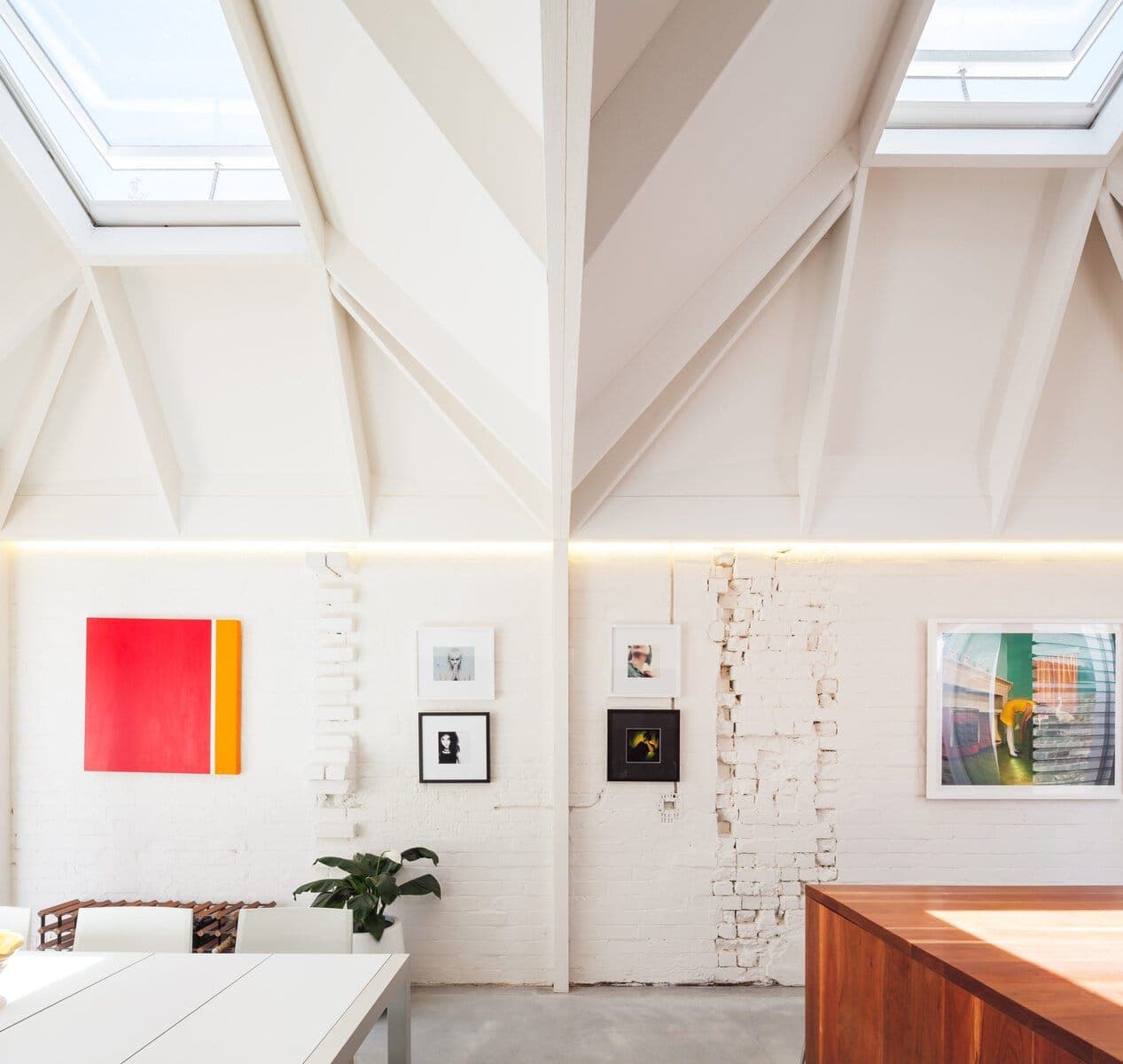 Bright modern interior with a high ceiling, artistic decor, and natural light.