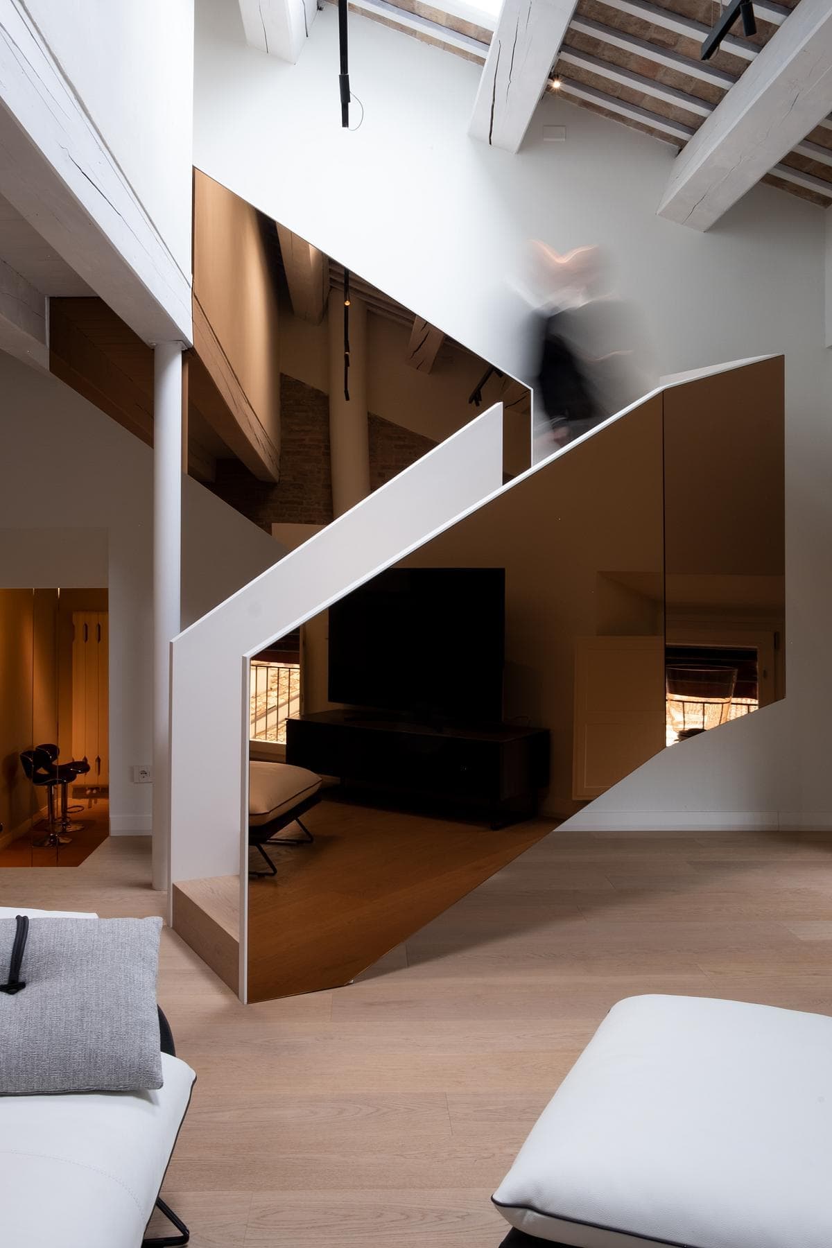 Contemporary living room with unique staircase, warm tones, and inviting seating area.