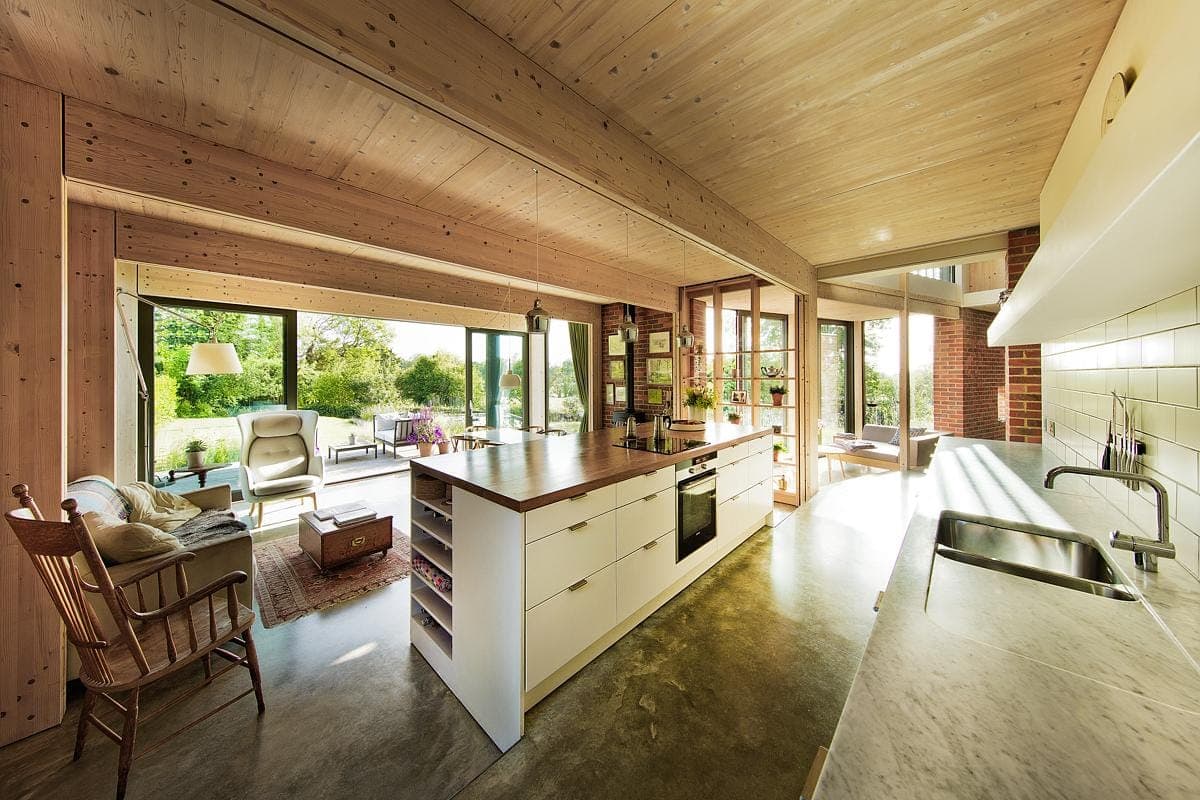 Stylish modern kitchen and living area with natural light and warm wooden accents.